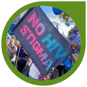 "no hiv stigma" flag at a rally (surrounded by a mossy green bubble outline)